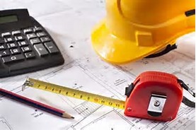 Hard hat and tape measurer over construction plans