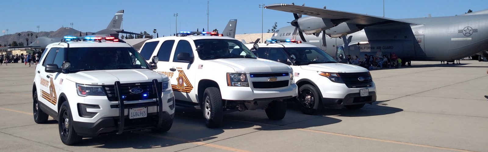 Three SB County Sheriffs Department cars with Planes on runway