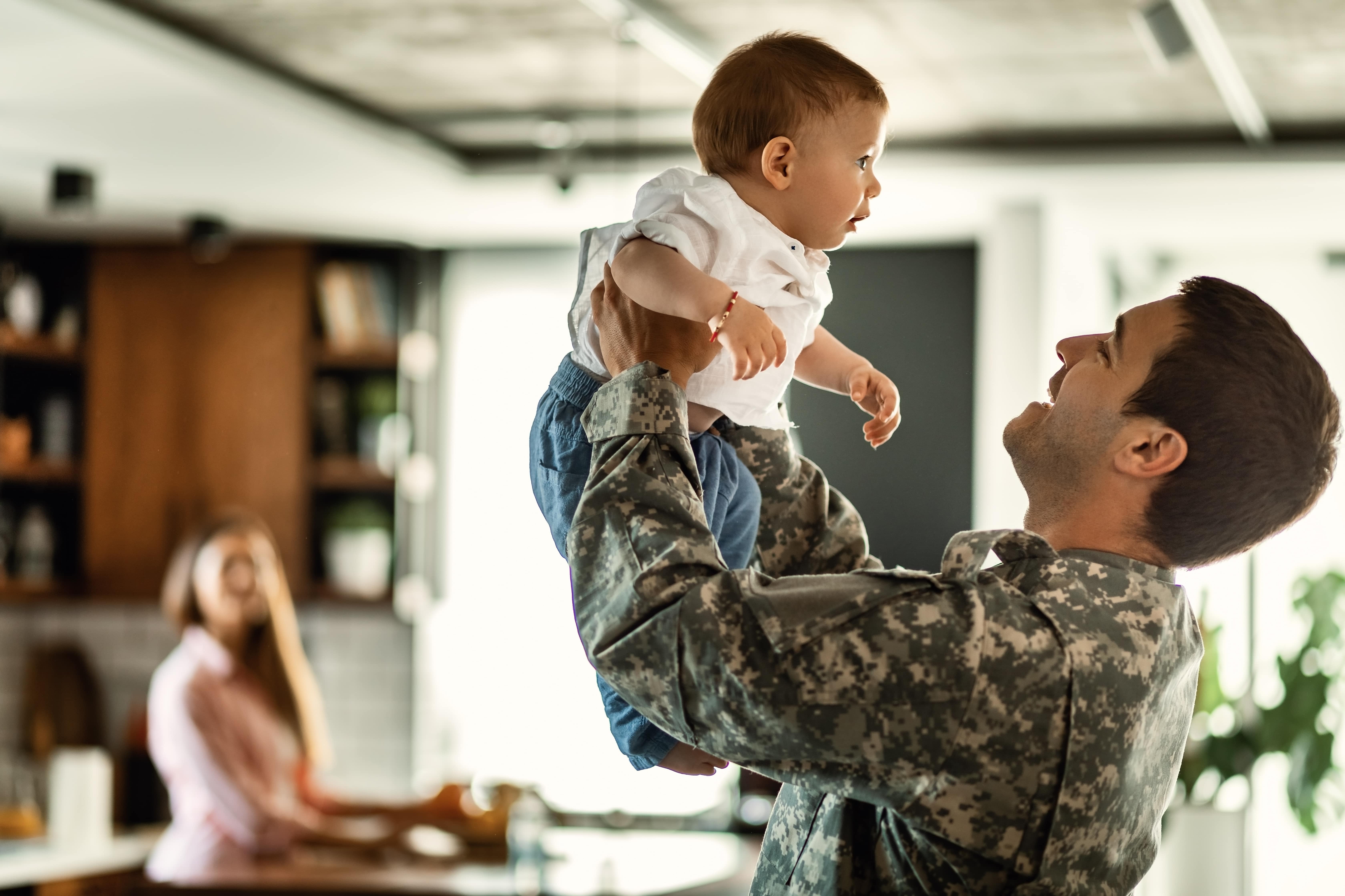 Veteran holding up baby