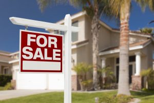 House with a For Sale sign in front yard