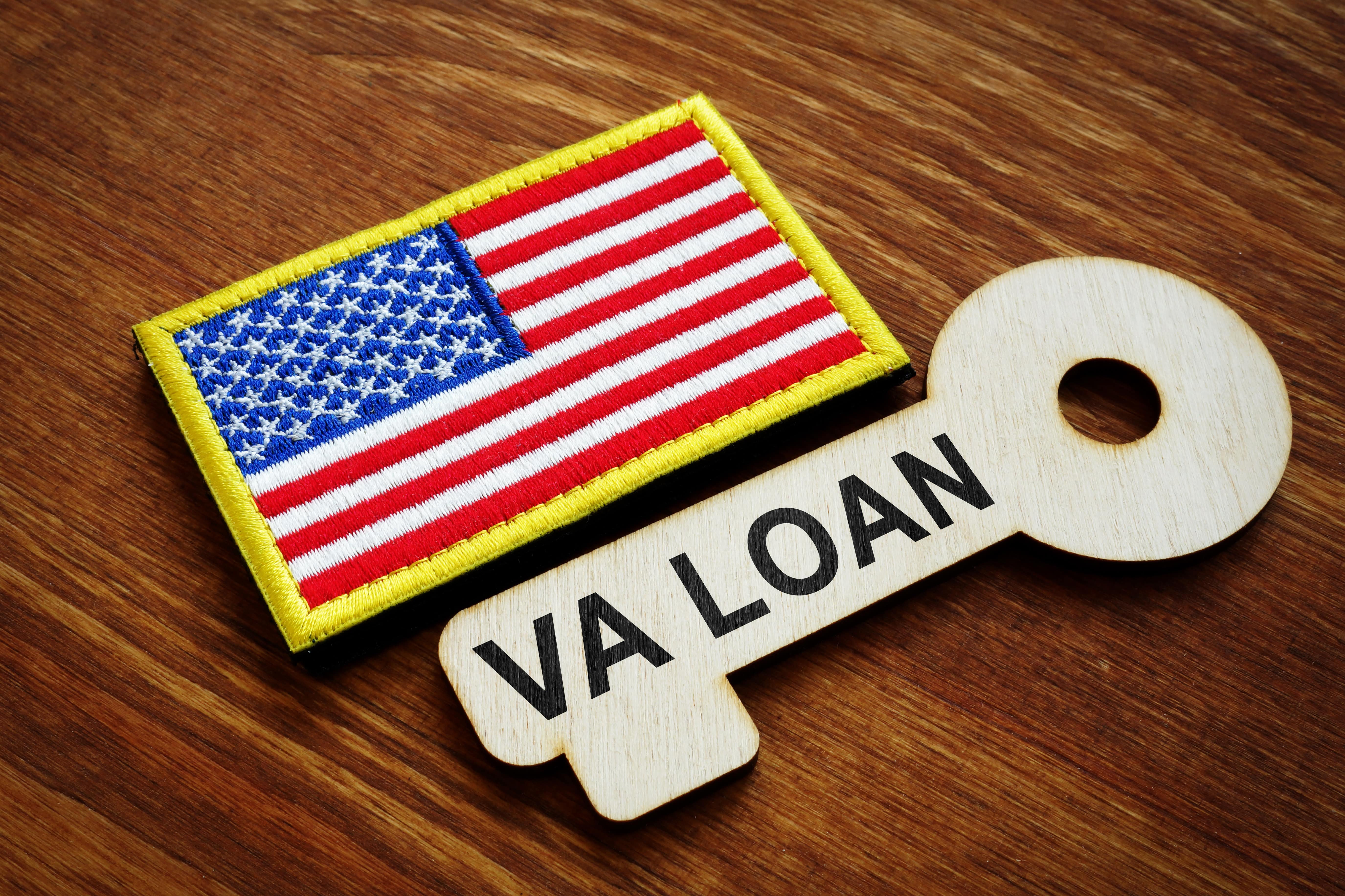 VA loan written on a wooden key and the American flag on a uniform badge.