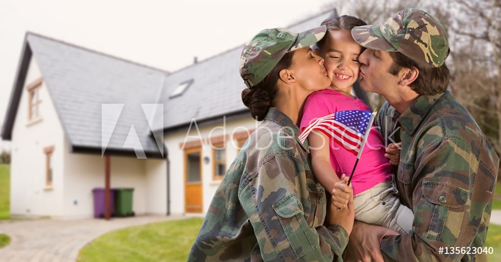 Mother and father veterans kissing their child